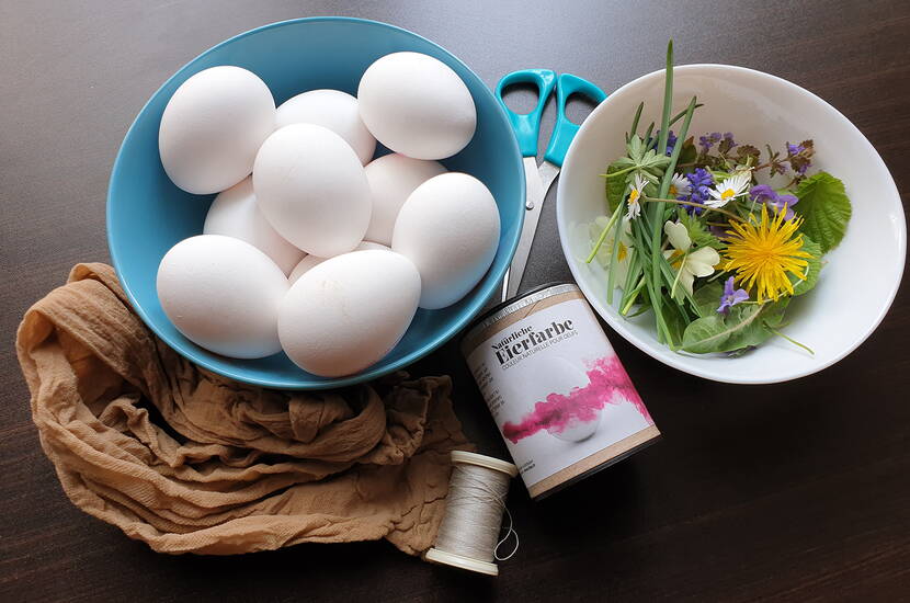 Zoom: Filigrane weisse Blüten- und Blättermuster zieren die gefärbten Ostereier, die in leuchtenden Lila-, Pink- bis Fuchsia-Tönen den österlichen Brunch-Tisch schmücken. Je nach Beschaffenheit der Eierschalen ergeben sich dezente bis knallige Farben, die für einen Wow-Effekt sorgen.