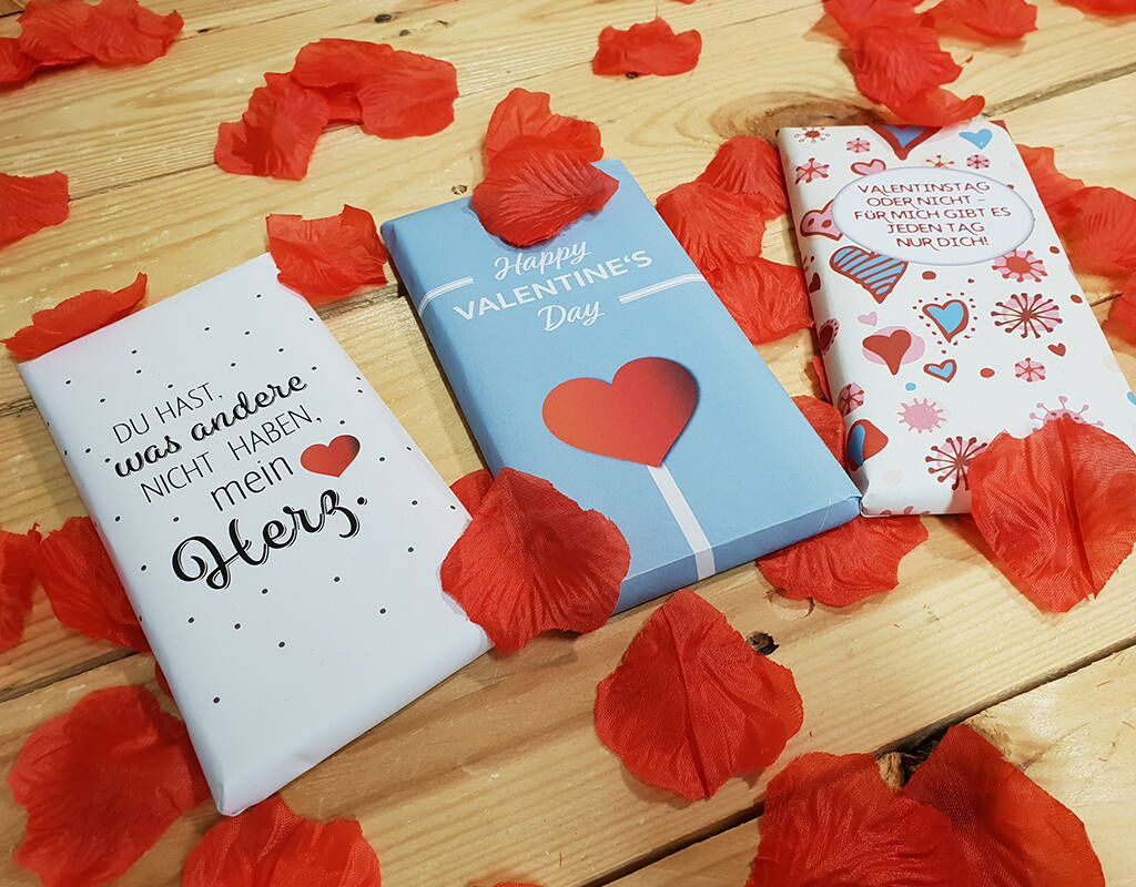 Mit unseren eigens für den Valentinstag kreierten Schokoladenverpackungen wird auch eine simple Tafel Schokolade zum Herzensgeschenk an die Liebste oder den Liebsten. Da benötigst dafür lediglich unsere Vorlage, welche du als PDF-Datei herunterladen kannst, einen Farbdrucker, weisses Papier, eine Schere, einen Leimstift und natürlich eine Tafel Schokolade. Happy Valentine's Day