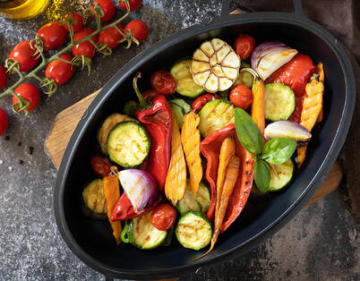 Verdure grigliate colorate in teglia nera Verdure grigliate con peperoni, zucchine e pomodori – le verdure cotte si conservano massimo 2 giorni in frigorifero