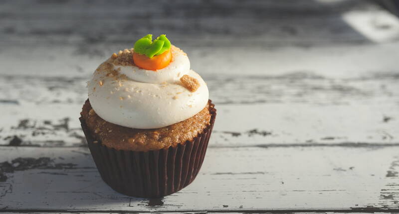 Ein wunderbar saftiger und fluffiger Muffin, gekrönt von einem herrlichen Frischkäse-Frosting und garniert mit einem Marzipan-Rüebli und Mandelkrokant.