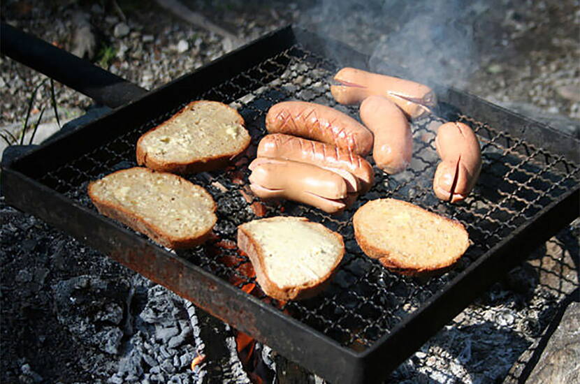 Auch Knoblauchbrot kann relativ einfach beim Bräteln zubereitet werden. Vorausgesetzt, es steht ein Grillrost zur Verfügung. Alternativ können die Brotscheiben sonst auf einen langen Stock aufgespiesst werden. Dabei empfiehlt es sich, zwei Scheiben auf einmal aufzuspiessen. Die bestrichenen Flächen dabei aufeinanderlegen, damit die Knoblauchbutter weniger stark heruntertropft.