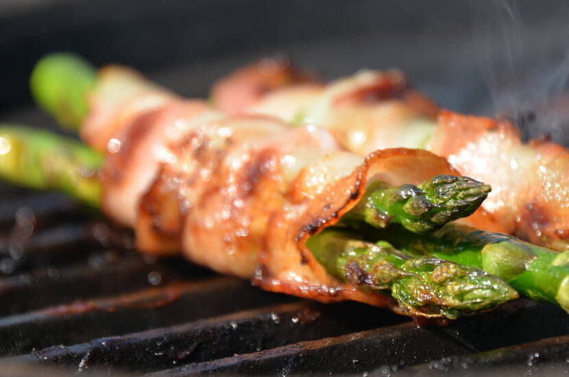 Um den zarten Spargel vor der Hitze des Grills zu schützen, diesen mit Speck umwickeln.