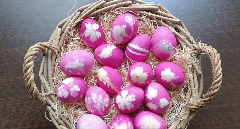 Fiori e foglie bianche in filigrana adornano le uova di Pasqua tinte, che decorano la tavola del brunch di Pasqua in tonalità brillanti di viola, rosa e fucsia. A seconda della consistenza dei gusci d'uovo, i colori vanno dal sottile al brillante e creano un effetto wow.